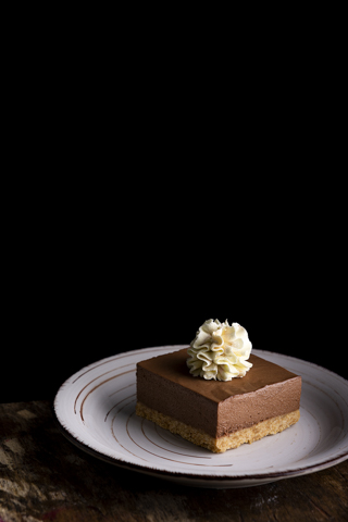 mousse de chocolate  con crema chantilly fondo negro sobre madera vertical mousse de chocolate con crema chantilly fondo negro sobre madera vertical